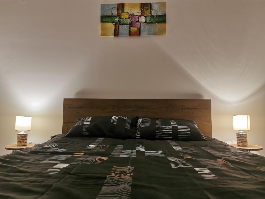 a bedroom with a large bed with two lamps at LoLa5 in Novi Grad