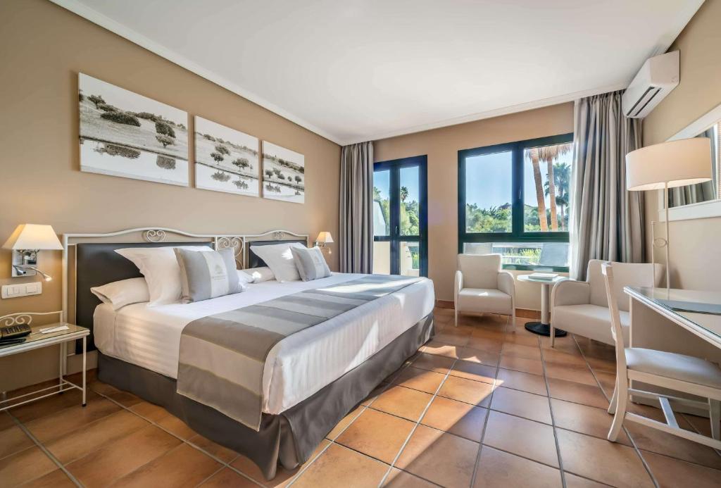 um quarto de hotel com uma cama e uma secretária em Barceló Jerez Montecastillo & Convention Center em Jerez de la Frontera