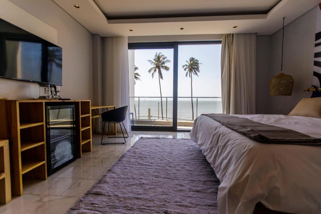 a bedroom with a bed and a view of the ocean at Cowork Lab Suites in Maputo