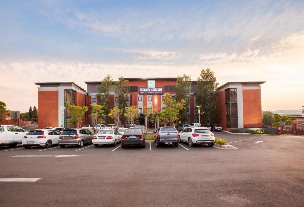 逊邱伦Road Lodge Centurion的建筑物前停放汽车的停车场