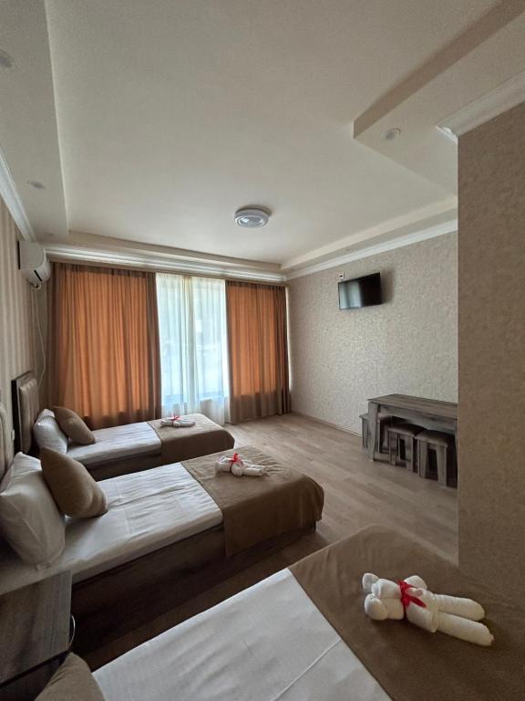 una camera d'albergo con due letti e una grande finestra di SoSe a Vaykʼ