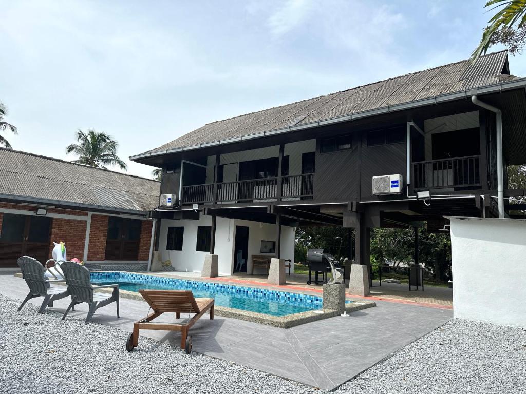 a house with a swimming pool next to a building at The Wooden Retreat by Elite Stay in Port Dickson