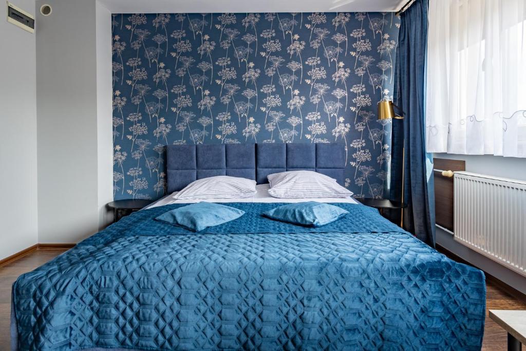 チェンストホヴァにあるApartamenty Komfortのベッドルーム(青いベッド1台、青い毛布付)