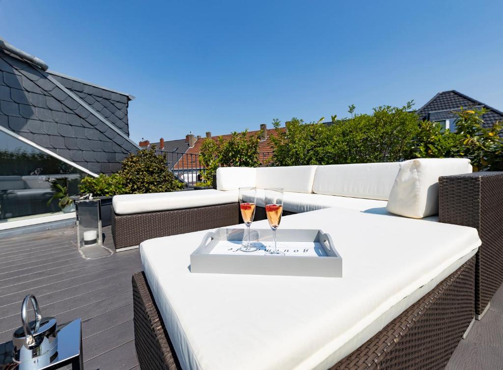 a white table with two wine glasses on a balcony at Penthouse with Whirlpool Central in Düsseldorf