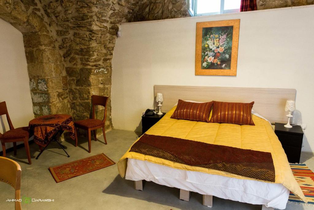 1 dormitorio con 1 cama, mesa y sillas en Al-Hakim Boutique Hotel Old Town Nazareth, en Nazaret