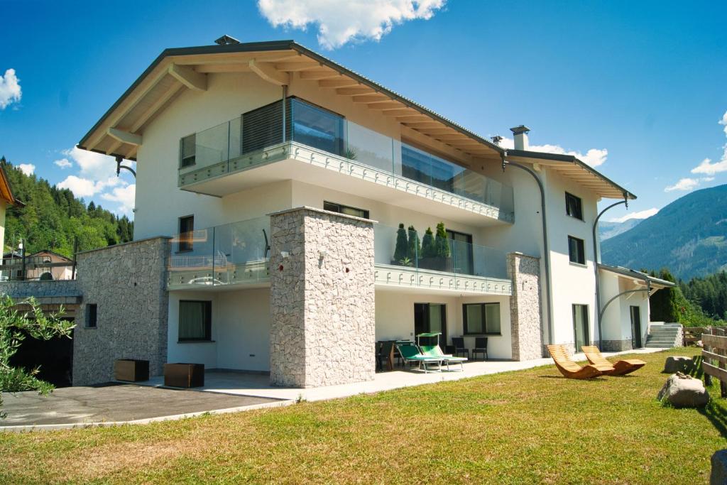 a large house with a balcony on top of it at Relais Dolomiti in Bedollo