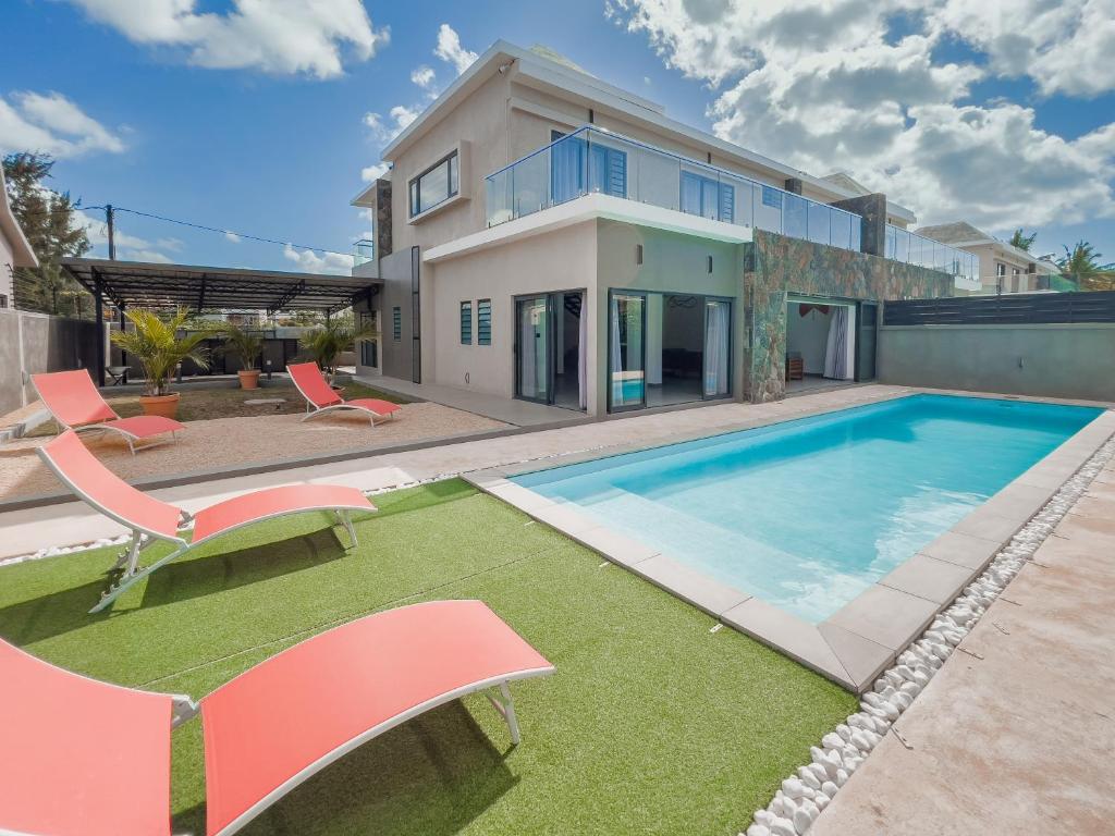 una casa con piscina e due sedie di Résidence Mo'Villa - Spacious 4 Bedrooms Villa with infinity pool a Grand Baie
