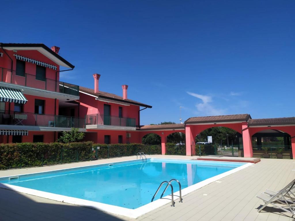 a large swimming pool in front of a building at Residence Corallo in Rosolina Mare