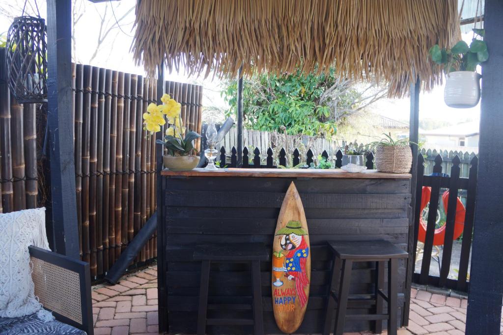 a surfboard sitting next to a bar with a table at Palm Breeze - 4 bedroom -Walk to the beach in Bargara