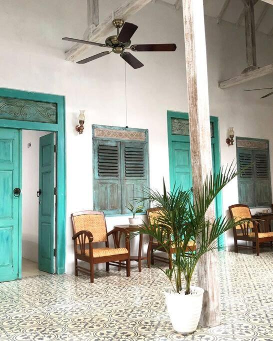 a room with a table and chairs and a ceiling fan at The Blue Joglo Jogja in Yogyakarta