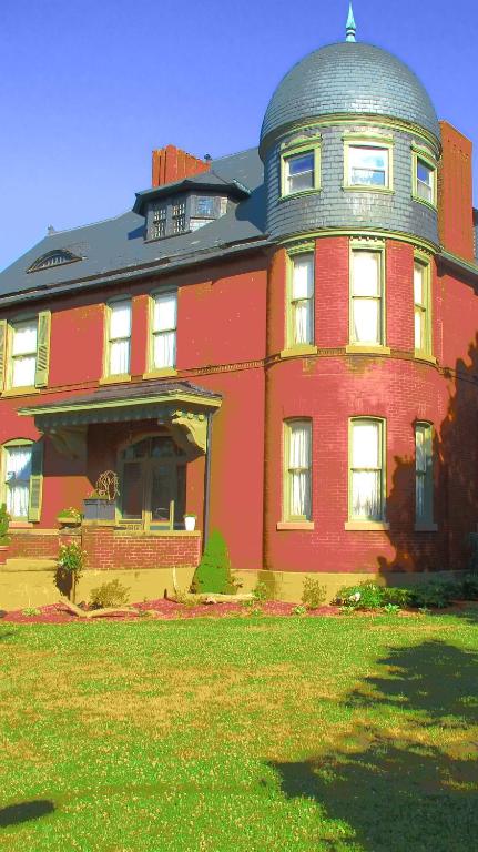 ein großes rotes Haus mit einer Kuppel darüber in der Unterkunft Johnstone Mansiion in Keokuk