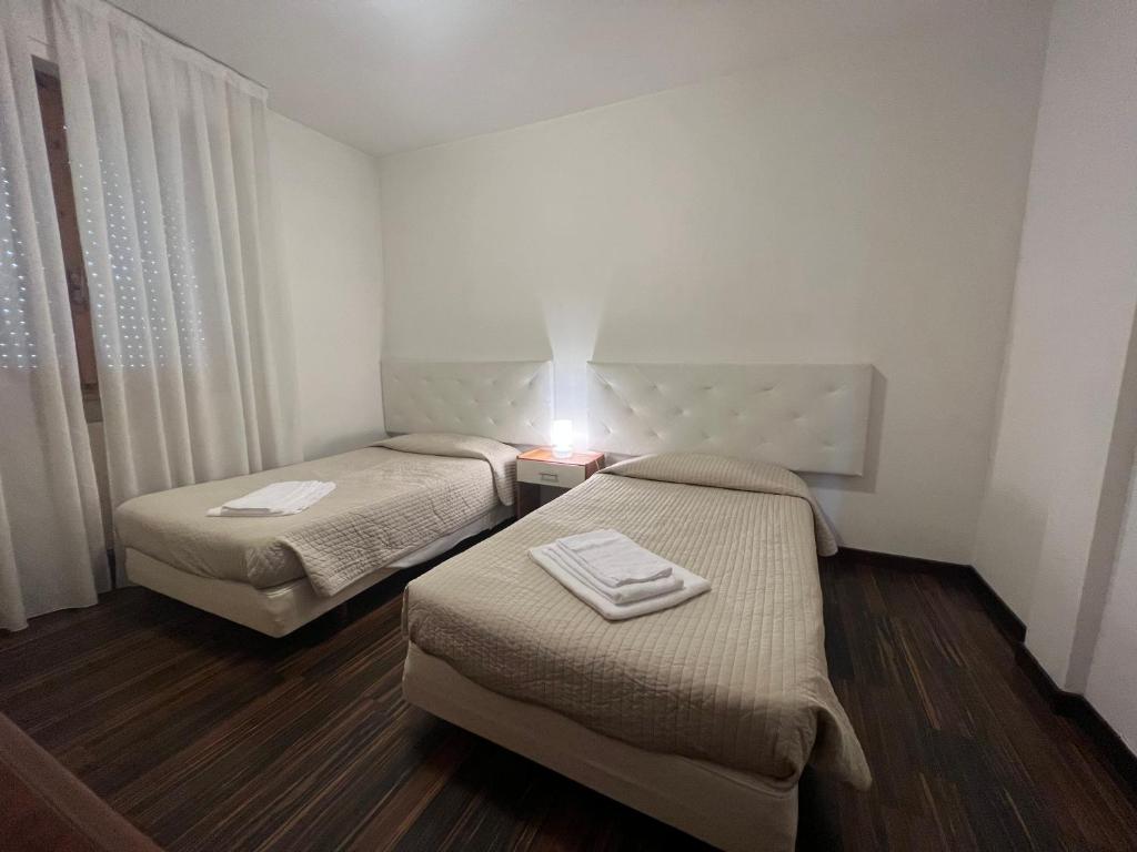 ein kleines Zimmer mit 2 Betten und einer Lampe in der Unterkunft Appartamento Malpigihi 40 in Arezzo