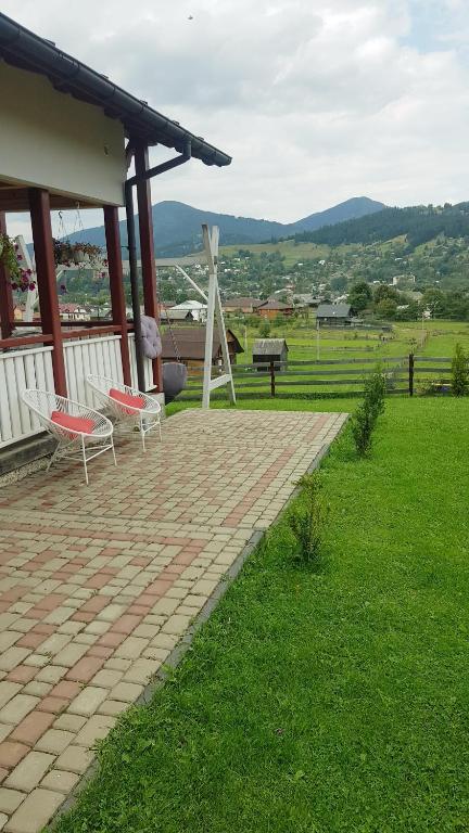 a brick patio with two chairs on a house at Andrhouse in Verkhovyna