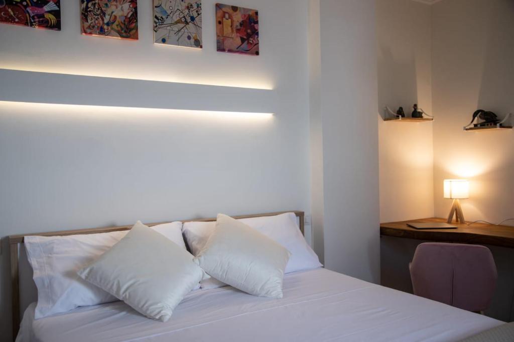 a bedroom with a bed with white pillows and a desk at Casa Dei Vettii B&B in Pompei Scavi