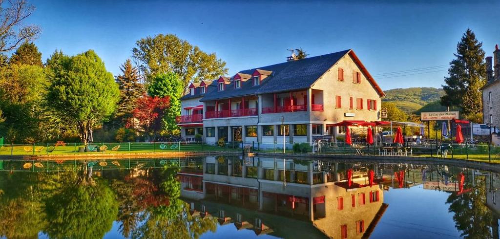 a house with a reflection in the water at Le Lac Des Moines in Condat