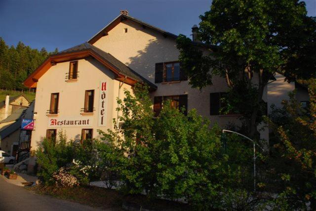 a white building with a sign on the side of it at La Ferme du Bois Barbu in Villard-de-Lans