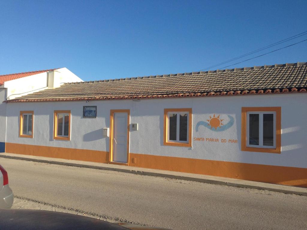 a white building with a sign on the side of it at Santa Maria do Mar Guest House in Peniche