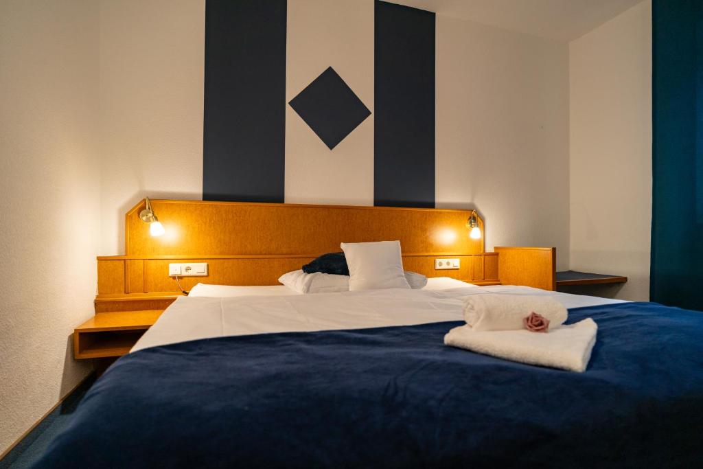 1 dormitorio con 1 cama grande y 2 toallas. en Waldhotel Surwold, en Surwold