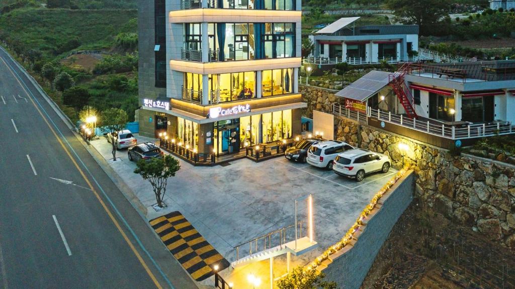 un gran edificio con coches estacionados frente a él en Paran Pension en Yeosu