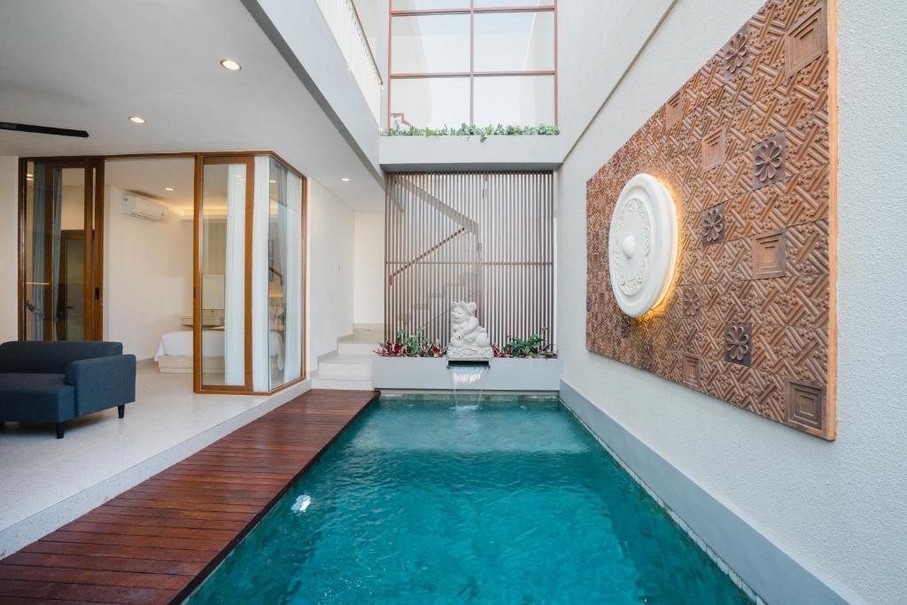 una piscina in una casa con un orologio sul muro di Dankalih Villa 3BR with Private Pool a Sanur