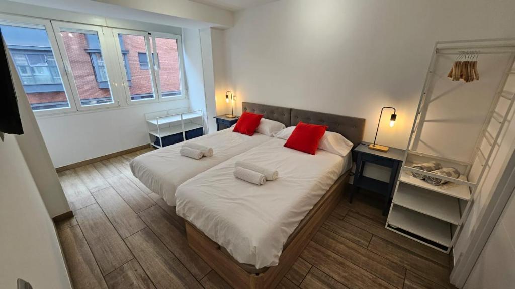 a bedroom with a large bed with red pillows at luminoso apartamento 6 personas pueblo nuevo in Madrid