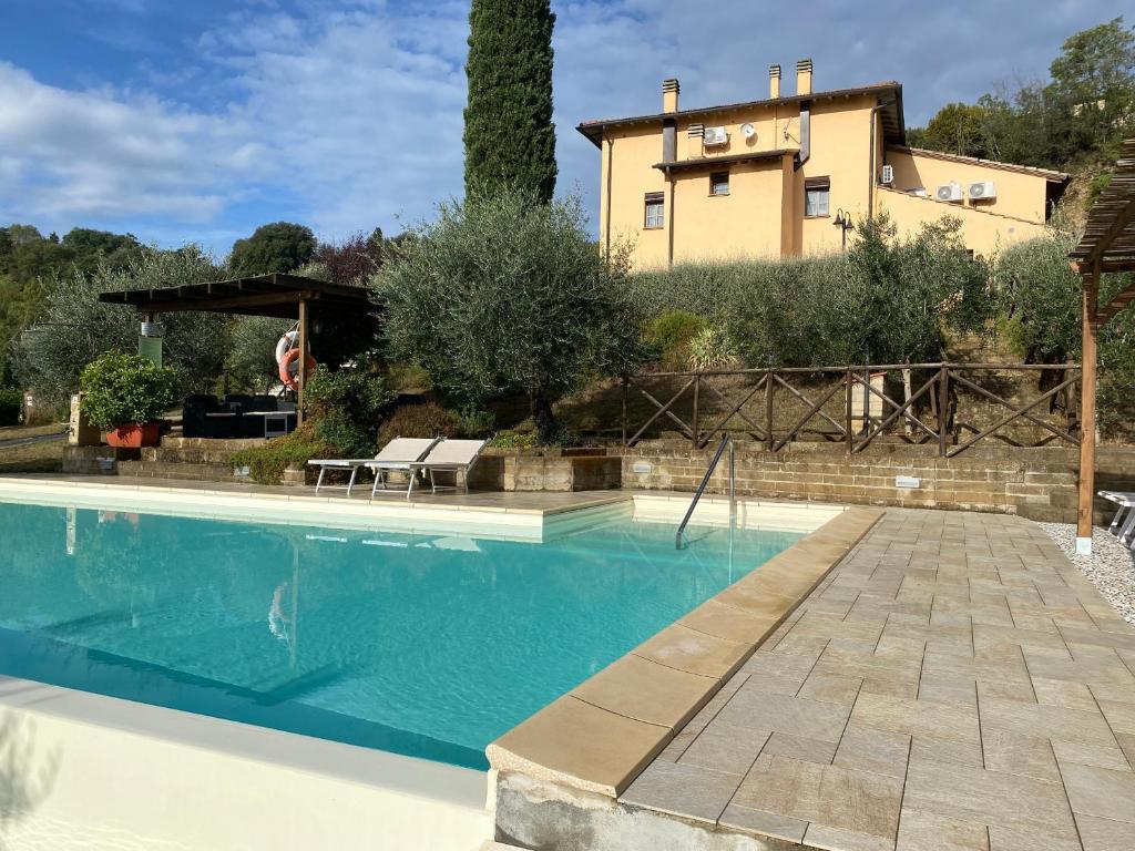 une villa avec une piscine en face d'une maison dans l'établissement Villa Le Ripe, à Gambassi Terme