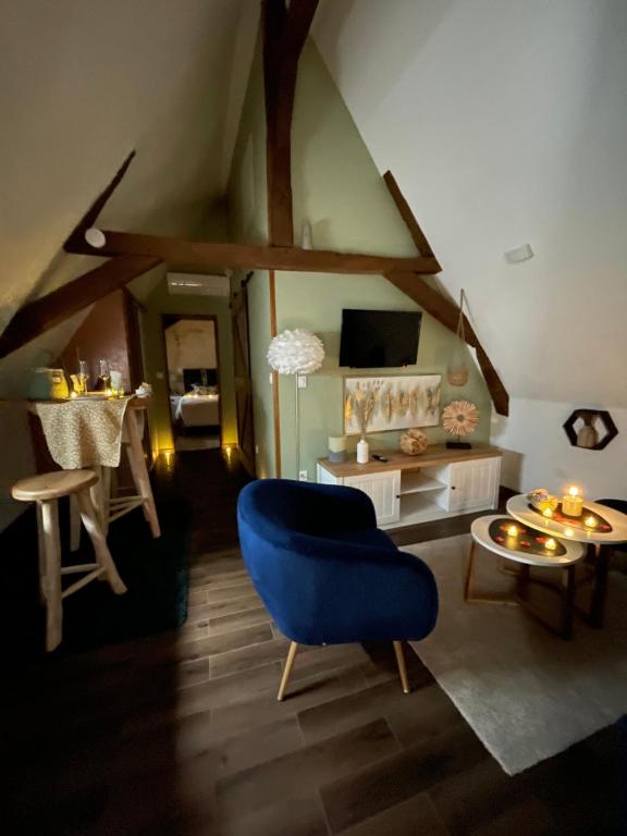聖阿芒萊索的住宿－Cense au Bois，客厅配有蓝色椅子和桌子