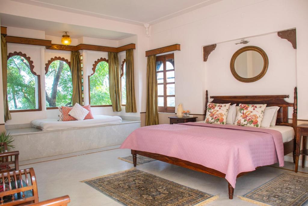 a bedroom with two beds and a mirror at Titardi Garh- 18th Century Castle Homestay in Udaipur