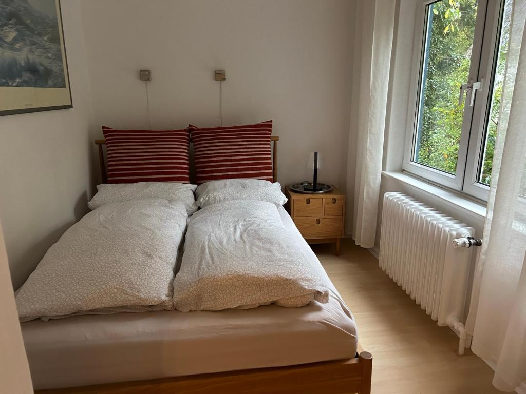 a bed in a white room with a window at Wohlfühlort in Felde bei Kiel in Felde