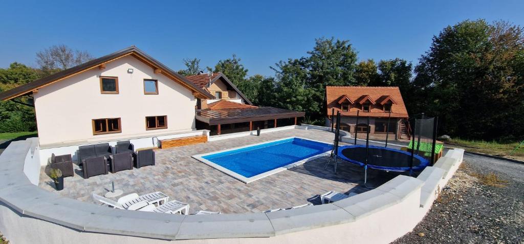 ein Haus mit einem Pool vor einem Haus in der Unterkunft Budimberg Kuća za odmor s bazenom in Ludbreg