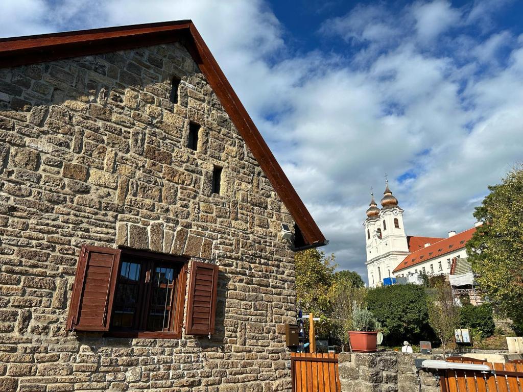 a stone building with a clock tower in the background at Piros Vendégház in Tihany
