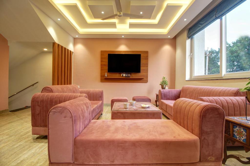 a living room with couches and a flat screen tv at Euphoria Luxury Villa - 5BHK - Private Pool - Jacuzzi, Baga in Baga