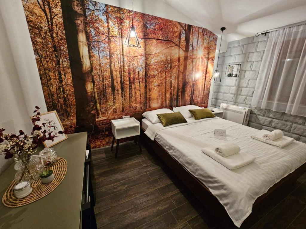 a bedroom with a large bed with a painting on the wall at Apartmani Drijen in Ravno
