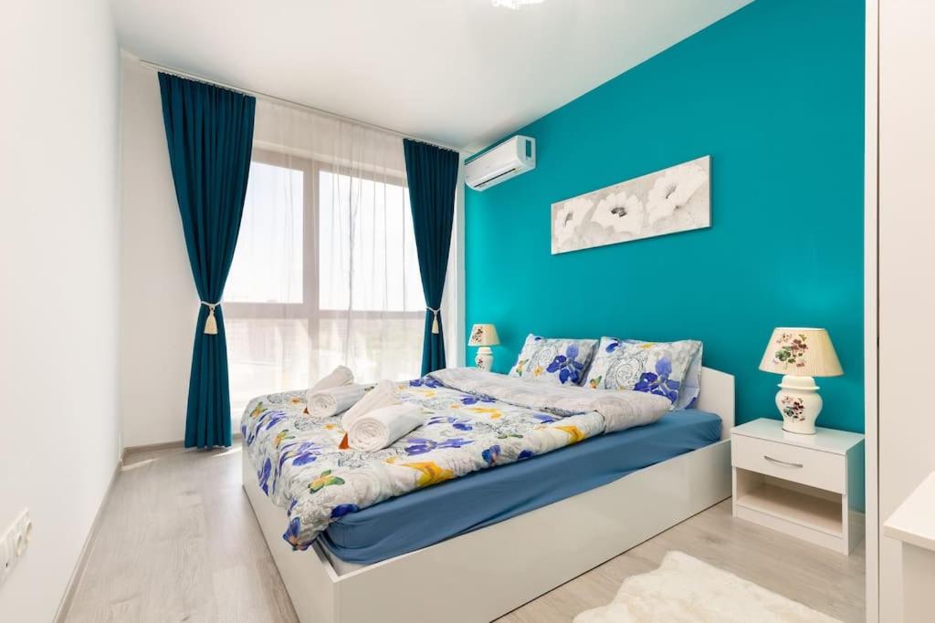 a blue bedroom with a bed and a blue wall at Comfy Apartment with Private Parking in Plovdiv