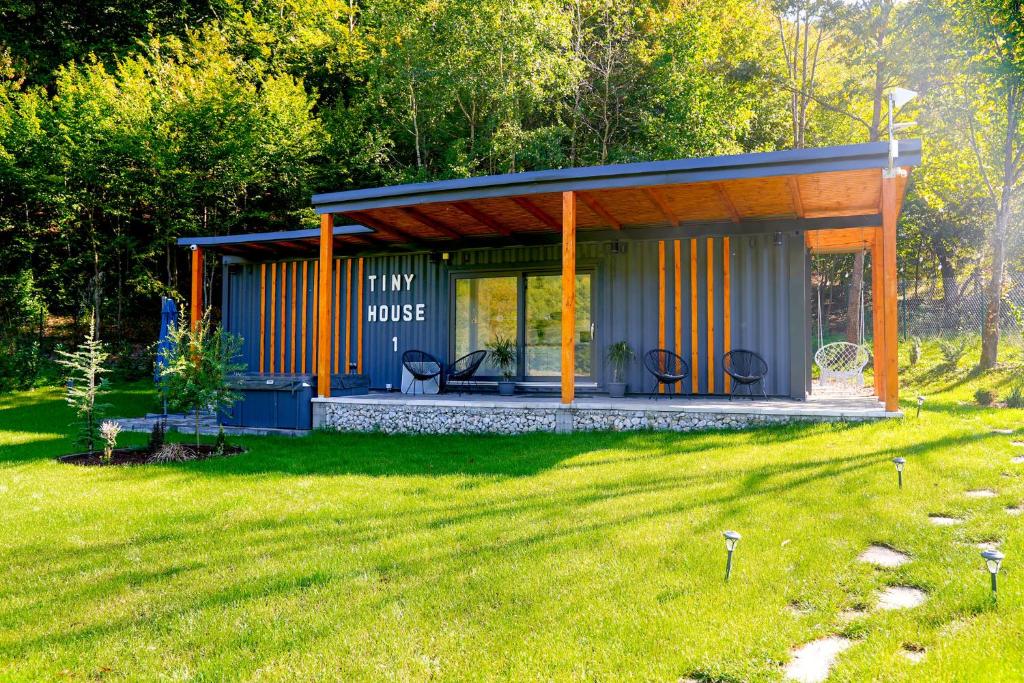 a small house with a roof in a yard at Tiny House by the forest 1 