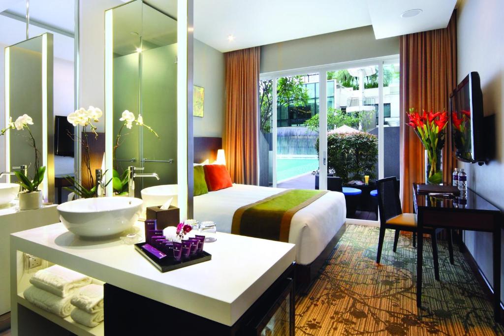 シンガポールにあるPark Regis Singaporeのベッドとバスルーム付きのホテルルームです。