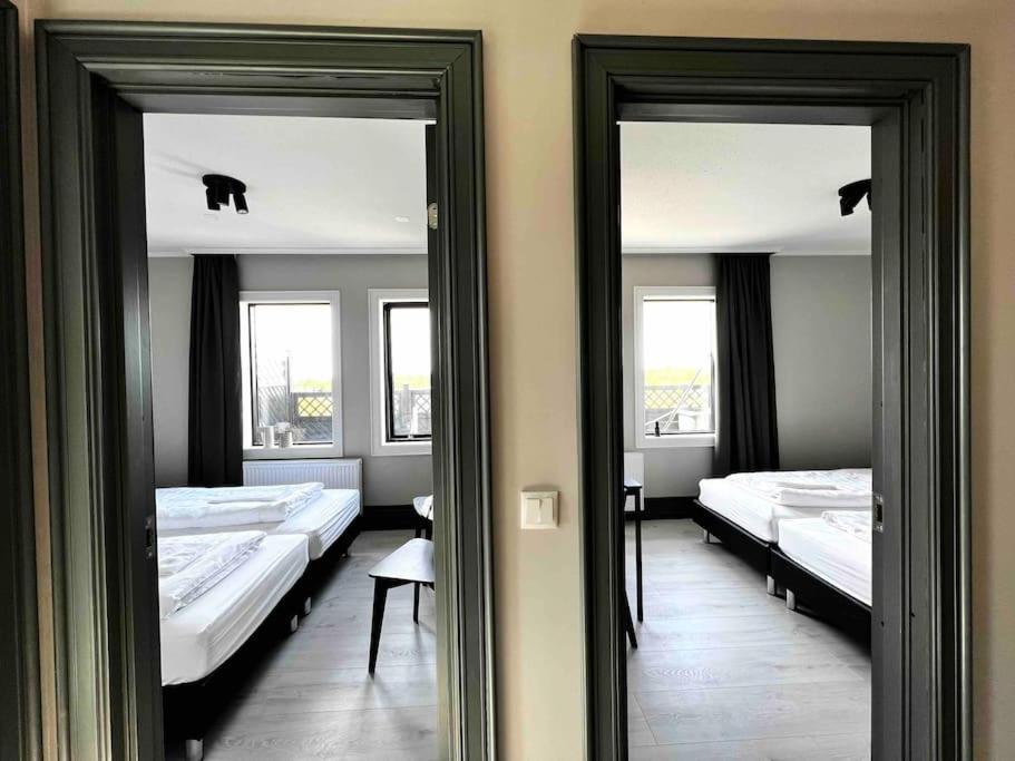 2 Spiegel in einem Zimmer mit 3 Betten in der Unterkunft The Greyhouse "Small Apartment" in Höfn