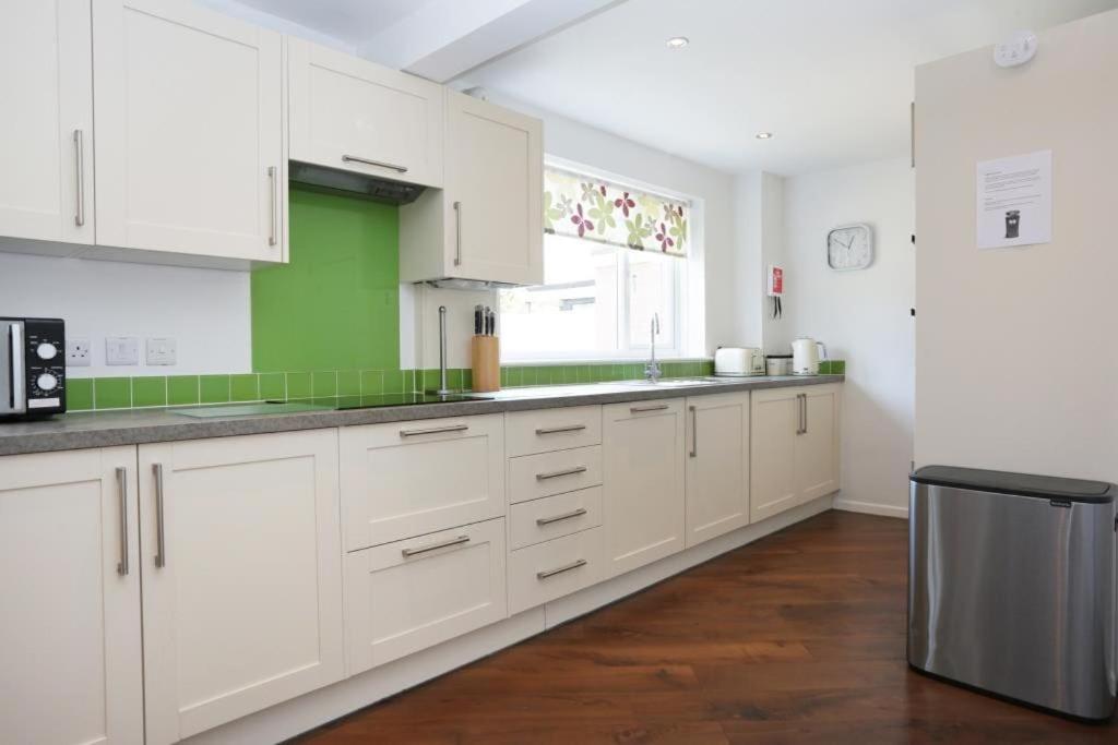 a large kitchen with white cabinets and a window at BOURNECOAST: Stones throw from the Quay - HB5666 in Bournemouth