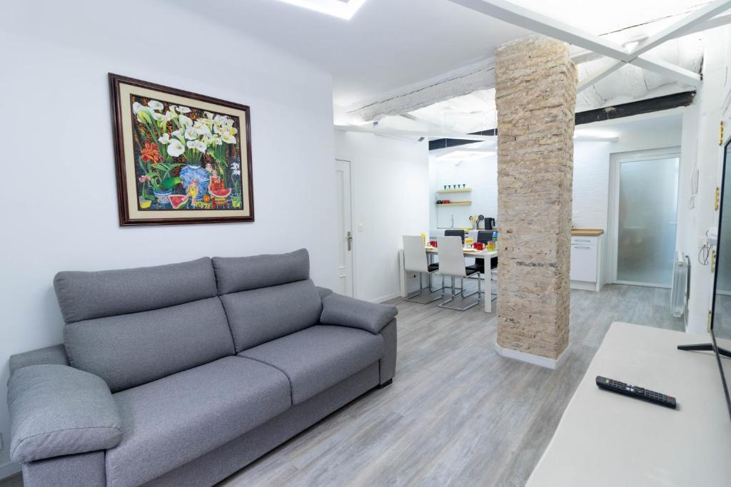 ein Wohnzimmer mit einem Sofa und einem Tisch in der Unterkunft Piso reformado en el centro histórico PARKING GRATIS Check-in 24 h in Saragossa