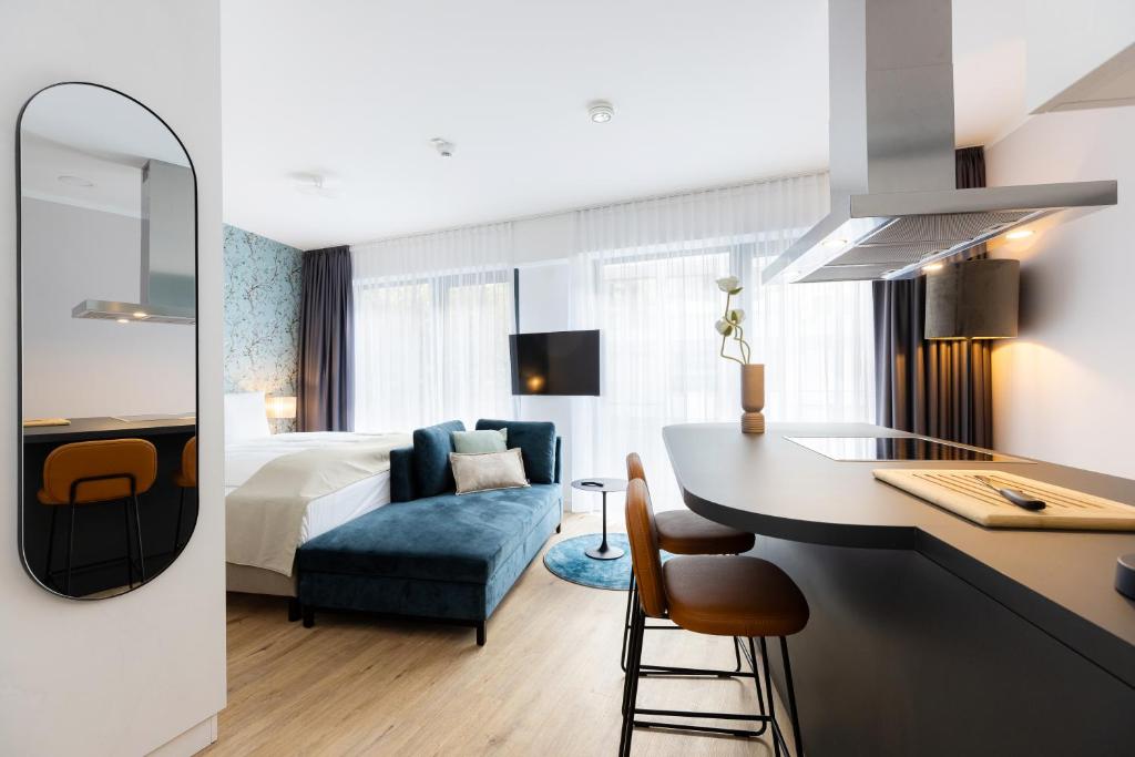 a hotel room with a kitchen and a bedroom at The Doorman Goethe Frankfurt am Main in Frankfurt/Main