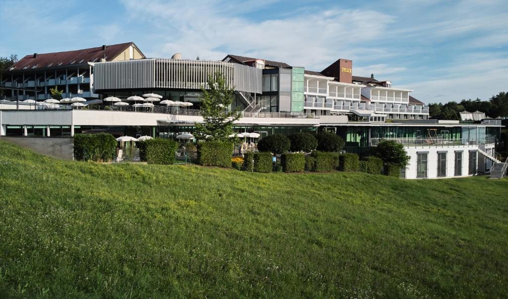 a large building with a grassy hill in front of it at Hotel Stoiser in Loipersdorf bei Fürstenfeld
