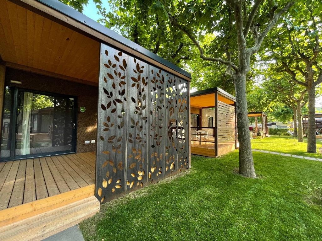 a house with a metal screen on the side of it at Camping Village Lago Maggiore in Dormelletto