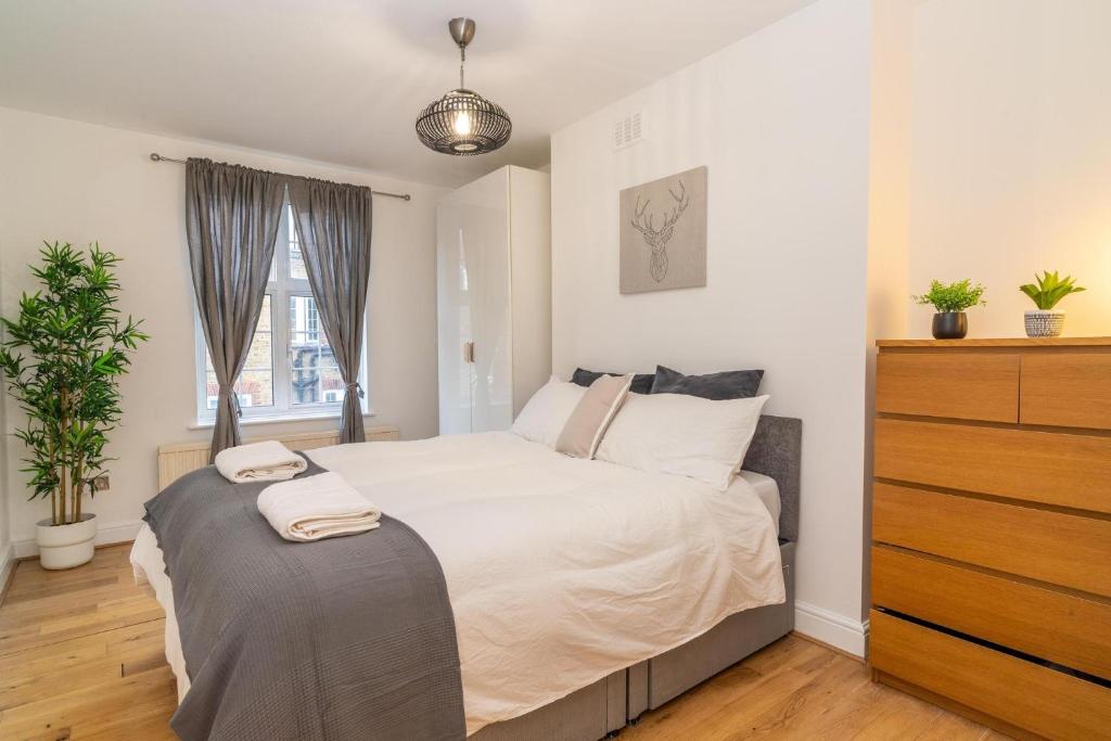 a bedroom with a bed with a dresser and a window at Location! 2 bed/2bath - Pro Host in London