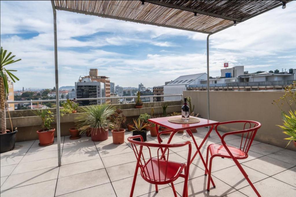 a patio with a table and chairs on a roof at Modern Luminous Rooftop Apartment in Porto
