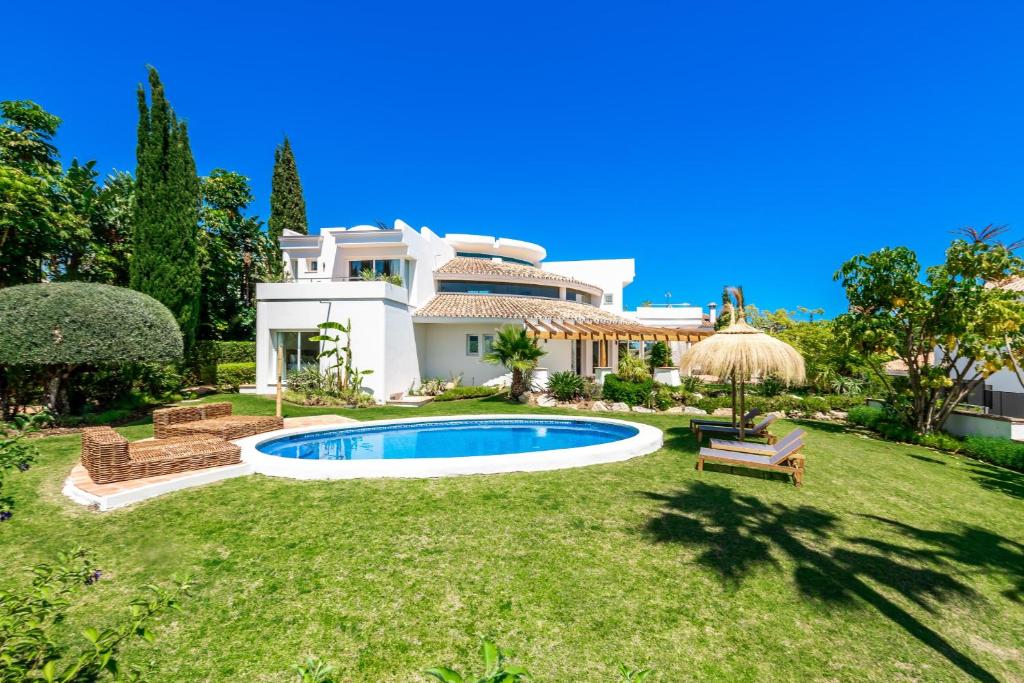 a large white house with a swimming pool in the yard at All About La Redonda Villa in Estepona