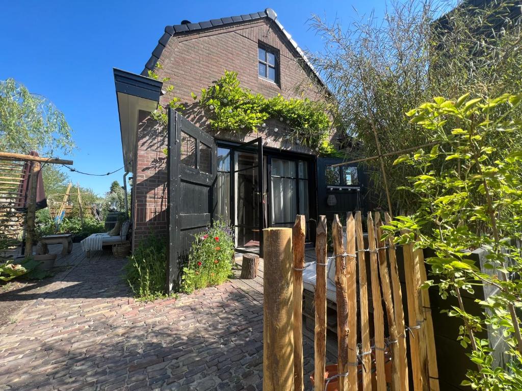 una casa con una recinzione di legno di fronte ad essa di Guesthouse Rotterdam, tinyhouse nearby Kralingen a Rotterdam