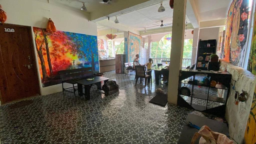 uma sala de estar com uma grande pintura na parede em NO NAME GUESTHOUSE em Arambol
