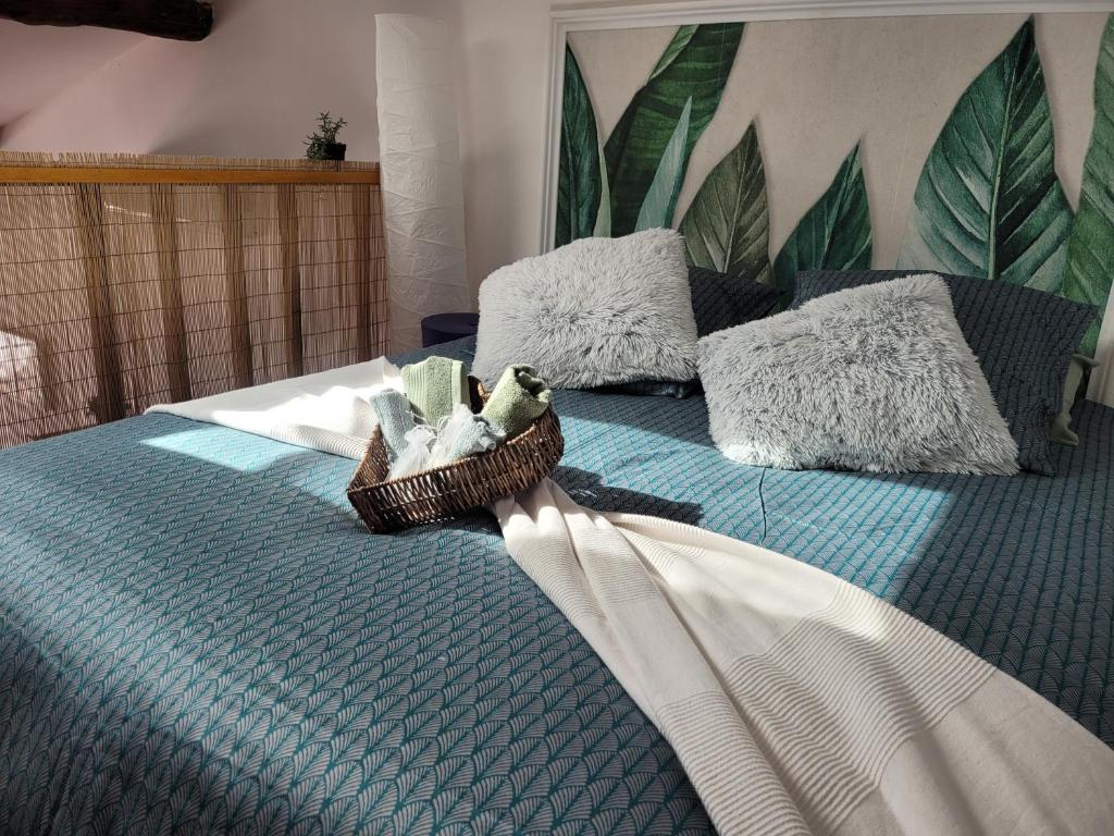 Bett mit einem Korb mit Handtüchern und Kissen in der Unterkunft île en Provence in Martigues