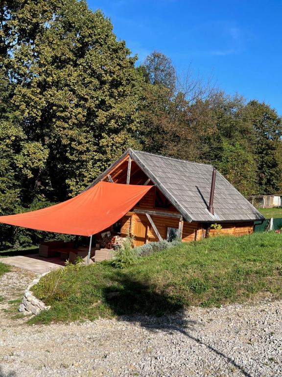 ein Haus mit einem großen orangenen Zelt davor in der Unterkunft Wood Cabin Hillside Retreat in Banja Luka