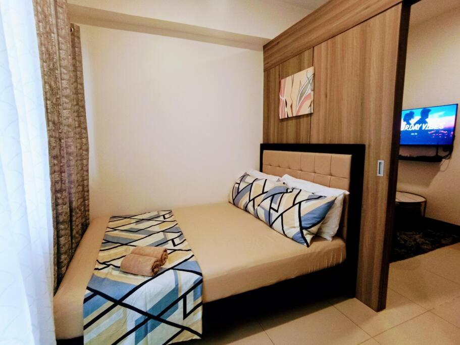 Dormitorio pequeño con cama y TV en Lovely Fame@4T, en Manila